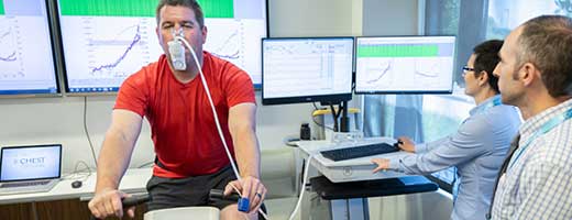 A person undergoes a cardiopulmonary exercise test while others look on