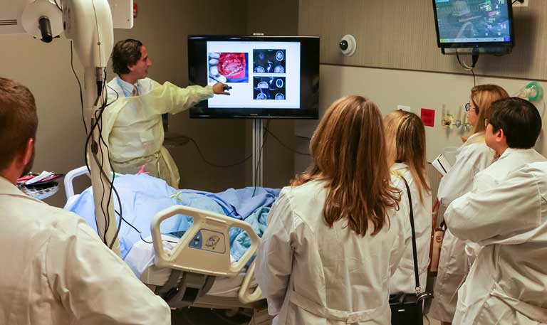 An instructor showing attendees medical images on a monitor
